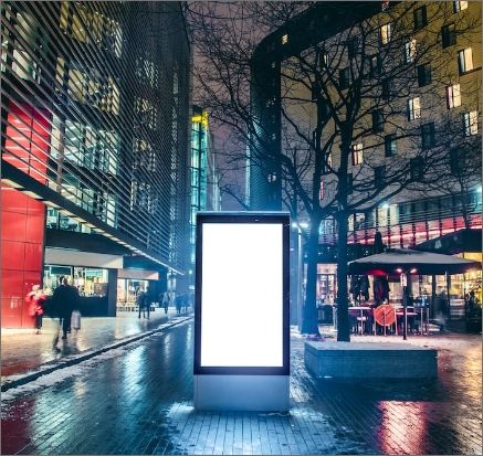 a white advertising screen in the middle of a city square
